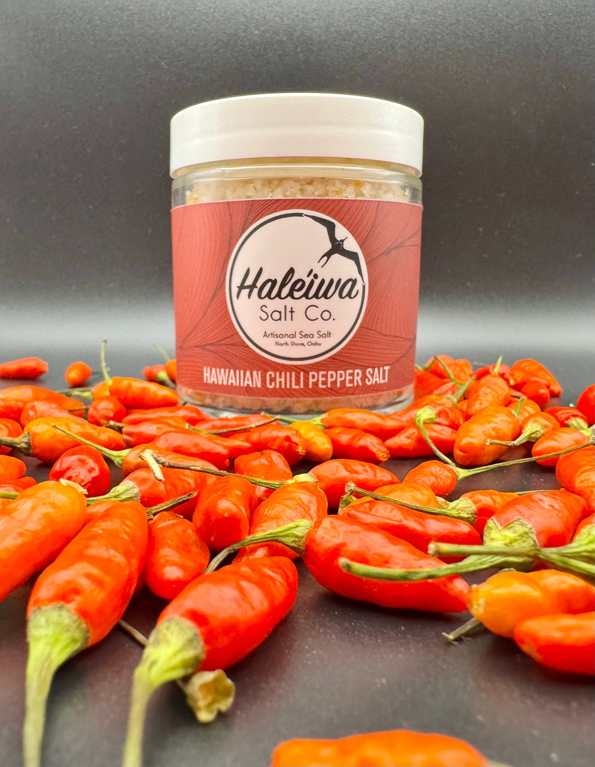 Hawaiian chili pepper salt with fresh Hawaiian chili peppers around it 